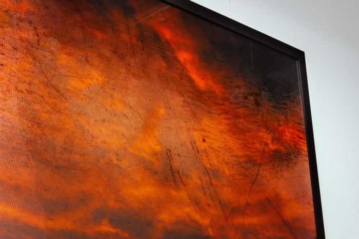 A framed photo of orange clouds at sunset