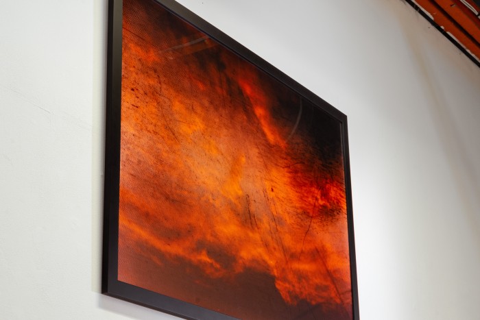 A framed photo of orange clouds at sunset