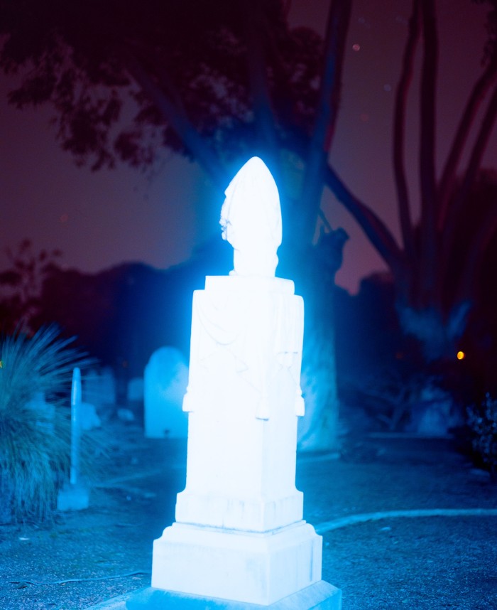 Photo of a glowing tombstone in a graveyard