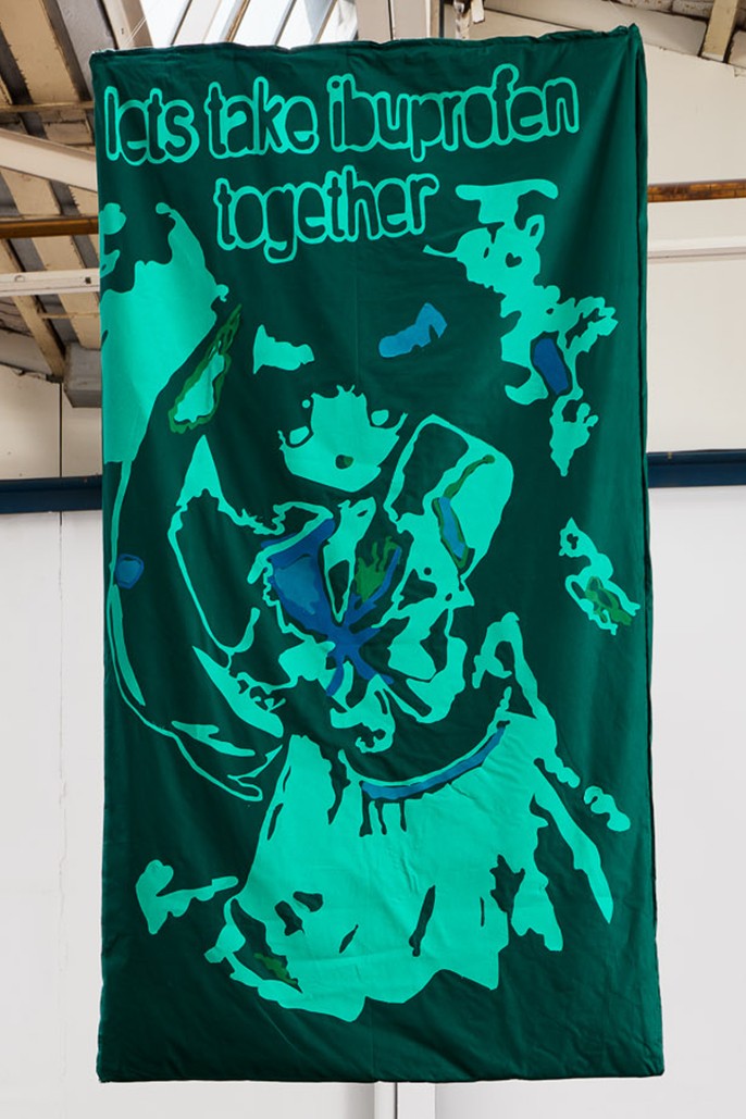Hanging quilt with appliuqe patchwork of an anime girl with the text "lets take ibuprofen together"