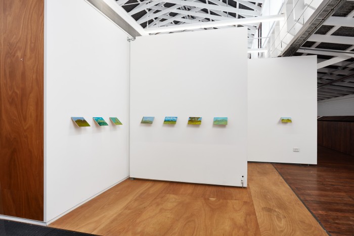 Install veiw of an upstairs space in the Stables at VCA. On the white walls hang small green paintings of imaginary parks all hung on a 45 degree angle and 1 metre above the ground.