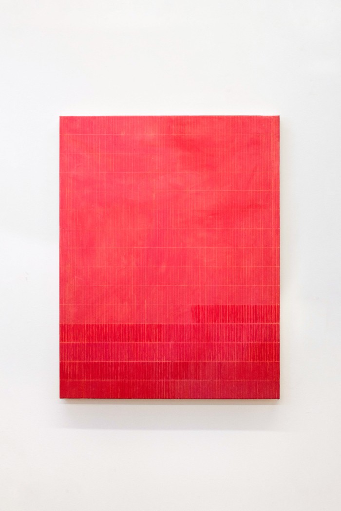 Bright red portait canvas with yellow grid lines in a vertical rectangular shape. The bottom of the canvas has extra strokes of red paint over the background.